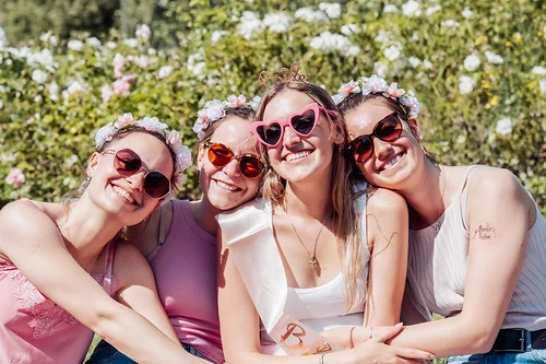 Quatre femmes souriantes avec lunettes de soleil et couronnes de fleurs posent ensemble lors d’un clip vidéo EVJF à Rouen