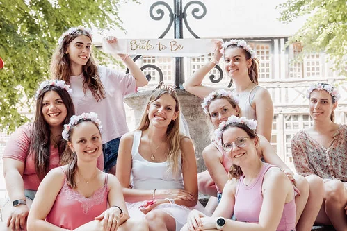 Groupe de femmes souriantes en tenue estivale avec couronnes de fleurs participant à un clip vidéo EVJF à Rouen