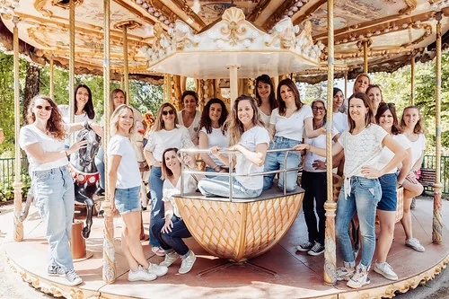 clip vidéo evjf à bordeaux avec un grand groupe de femmes posant sur un manège ancien en plein air dans un parc