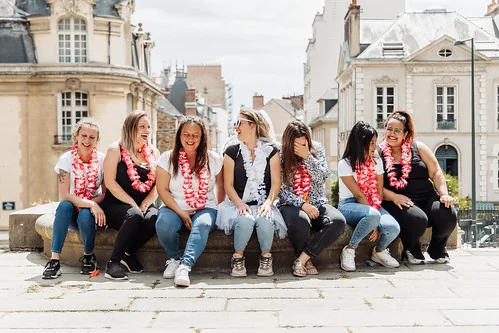 groupe de femmes assises dans le centre ville de rennes portant des colliers de fleurs