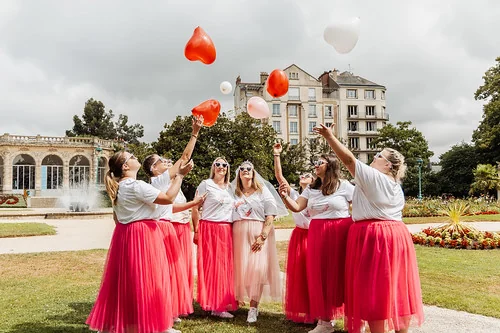 groupe de femmes en jupes roses celebrant un evjf a rennes avec des ballons en plein air