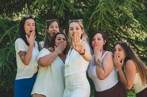 groupe de femmes celebrant un clip video evjf a tours avec la mariee mettant en avant sa bague dans un parc verdoyant