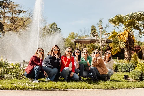 groupe de femmes assises devant une fontaine lors d un evjf a toulouse avec lunettes de soleil et tenues colorees