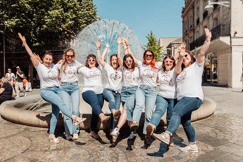 groupe d’amies en t shirts evjf à reims devant une fontaine, scène joyeuse illustrant combien coute un evjf à reims