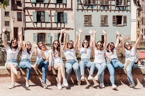 comment organiser un evjf a strasbourg groupe de copines joyeuses levant les bras dans la petite france