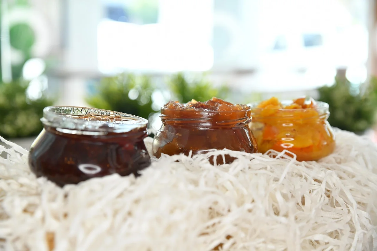 Trois pots de confiture artisanale aux couleurs variées présentés pour un brunch à La Baule.