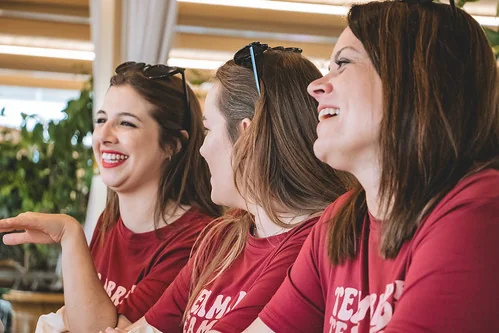 trois femmes en t shirt evjf rient et discutent lors d un cours de cuisine a deauville pour evjf