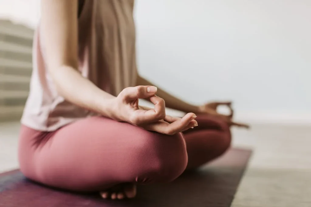 Gros plan d’une participante en méditation assise pendant un cours de yoga EVJF à Rennes.