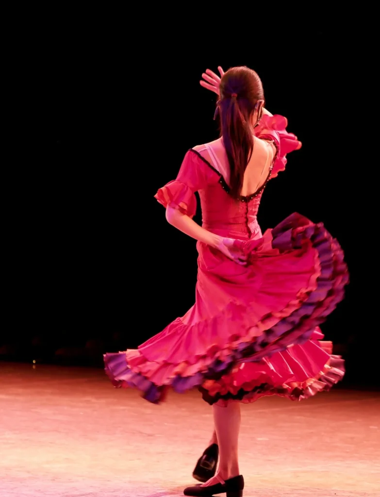Danseuse en robe rouge effectuant une figure de flamenco sur scène lors d'un EVJF à La Baule