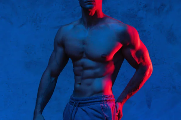 Danseur torse nu musclé en lumière bleue et rouge, evjf avec stripteaseur