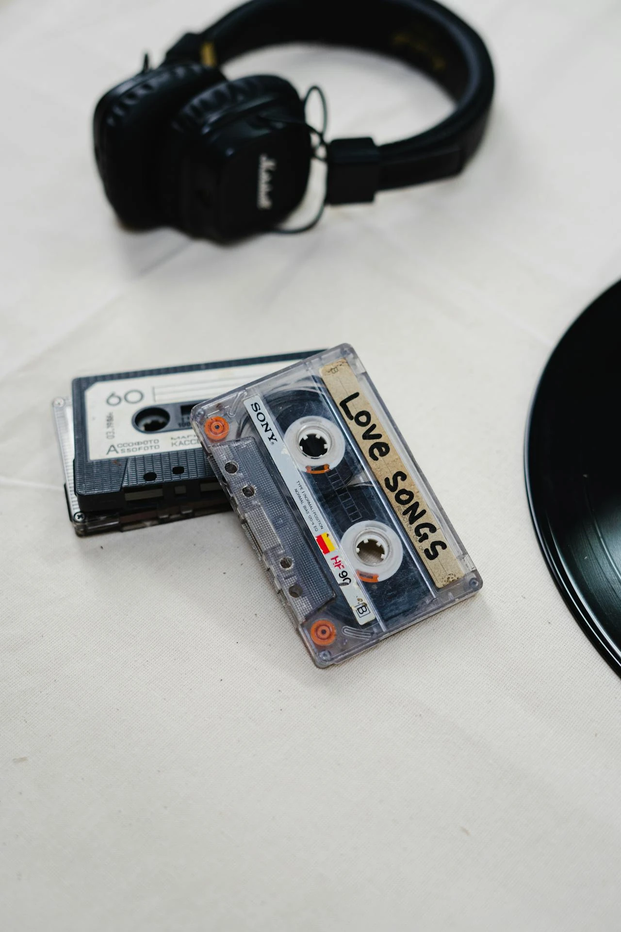 Cassettes audio vintage avec étiquette Love Songs et casque noir posé à côté