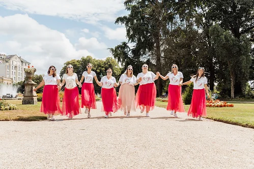 groupe de femmes en jupe rose et tee shirt blanc celebrant un evjf tout compris a rennes dans un jardin