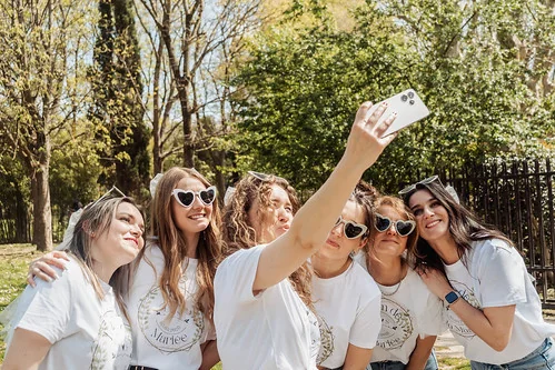 groupe de femmes en t shirt blancs prenant un selfie lors d un evjf tout compris a toulouse dans un parc ensoleille
