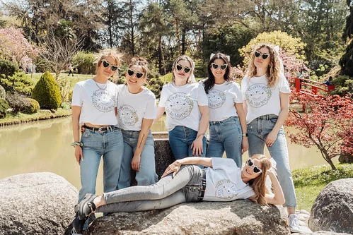 groupe de femmes en t shirt blanc et jean celebrant un evjf tout compris a toulouse dans un parc ensoleille