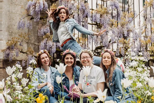groupe de femmes avec couronnes de fleurs posant dans un jardin fleuri lors d un clip video evjf a nantes