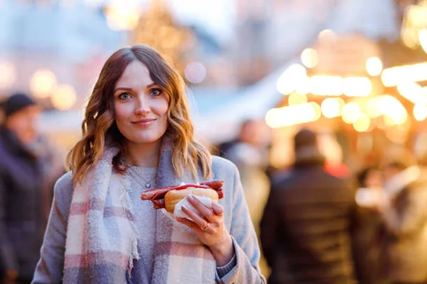 femme dégustant une spécialité locale lors d un food tour evjf à toulouse dans une ambiance de marché gourmand