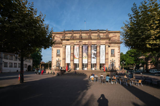 alt="Soirée au théâtre alsacien de Strasbourg EVJF à Strasbourg, façade monumentale du bâtiment avec ses colonnes et ses bannières culturelles"