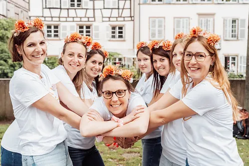 groupe de femmes en t shirts blancs et couronnes de fleurs posant ensemble lors d un koh bride koh lanta evjf a strasbourg
