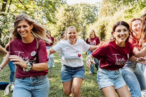 femmes souriantes courant dans un parc lors d un koh bride koh lanta evjf a strasbourg avec la mariee et sa team bride