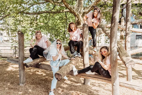 Future mariée avec ses amies en tenue décontractée posant sur une structure en bois lors d’un koh lanta evjf à nantes
