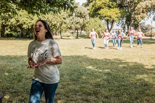 femme en tshirt bride court en riant dans un parc suivie de ses amies en tshirts roses lors dun evjf koh lanta a la rochelle