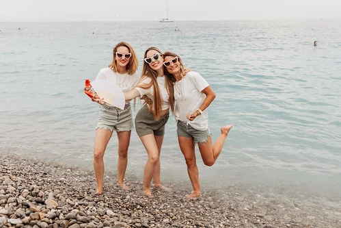 Trois amies souriantes posant sur la plage de Nice 