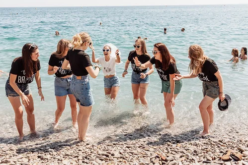 Amies célébrant un EVJF à Nice en jouant au bord de la mer, ambiance fun et festive inspirée de Koh Lanta sur la plage