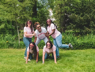groupe de femmes en tee shirt rose formant une pyramide humaine pendant une animation koh lanta evjf a tours