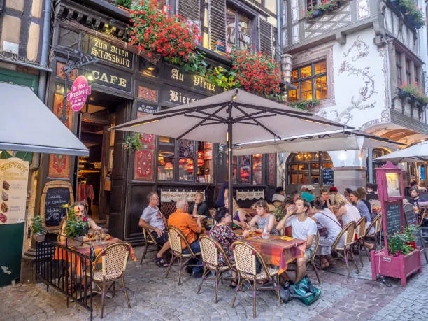 Terrasse animée d un restaurant traditionnel à Strasbourg dans le quartier de la Petite France un soir d été