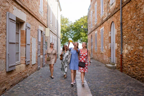 groupe de femmes en balade dans une rue en briques de toulouse lors d un sejour evjf avec logement en centre ville