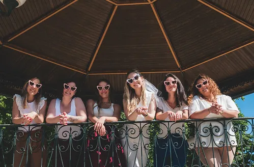 groupe de femmes en blanc avec lunettes en forme de cœur pose sous un kiosque à Tours, illustrant où faire du shopping à tours