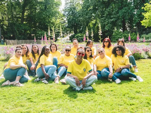 groupe d’amis en t-shirts jaunes assis sur l’herbe dans un parc fleuri à Tours, illustrant où manger à tours en plein air
