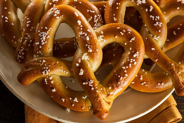 Peinture sur bretzel EVJF à Strasbourg, gros plan sur des bretzels traditionnels alsaciens dorés et saupoudrés de sel