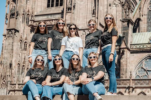 groupe de femmes en tee shirts team bride pose devant la cathedrale lors d un evjf illustrant pourquoi reserver une chasse au tresor evjf strasbourg