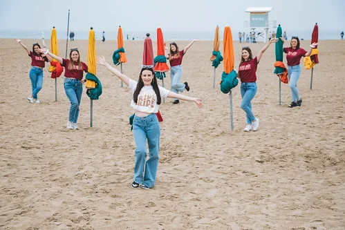 groupe de femmes en t shirt evjf pose sur la plage de deauville devant des parasols fermes