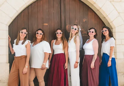 six amies posees ensemble devant une grande porte en bois
