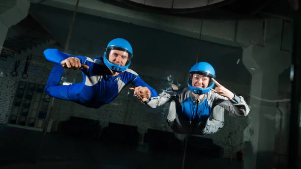 participants en combinaison et casque volant dans un simulateur de chute libre lors d un evjf a montpellier