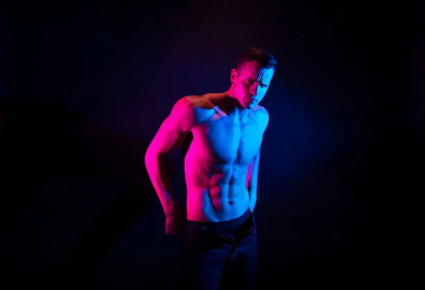 stripteaseur evjf à toulouse réalisant un show sensuel dans une ambiance lumineuse avec jeux de couleurs