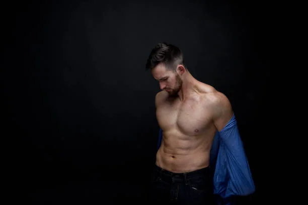 Stripteaseur EVJF à Strasbourg, danseur torse nu en train de retirer sa chemise sur scène dans une ambiance glamour et festive