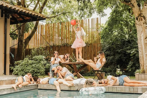 tout savoir sur shooting photo evjf à bordeaux : groupe d’amies posant autour d’une piscine, future mariée sur une table avec ballon