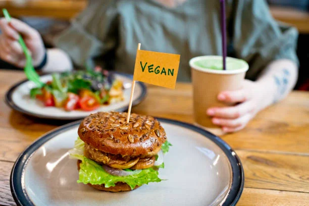 Burger vegan servi avec salade et boisson dans un restaurant convivial à Strasbourg, idéal pour un EVJF.