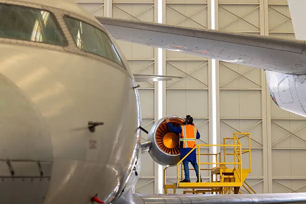 technicien inspectant le moteur d’un avion dans un hangar lors d’une visite aéronautique evjf à toulouse
