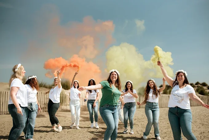 groupe de femmes utilise des fumigenes colores sur la plage pour illustrer 10 idees originales pour un evjf a montpellier