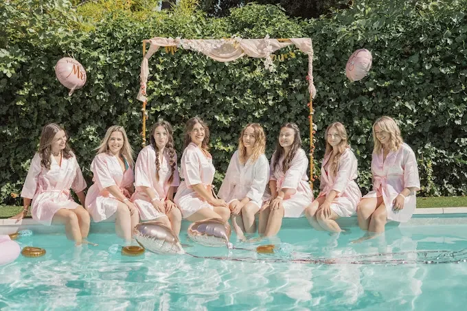 groupe de femmes en peignoir pose au bord d une piscine