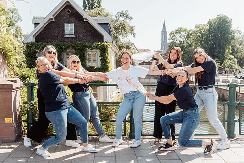 groupe d’amies tirant la future mariée en riant sur un pont