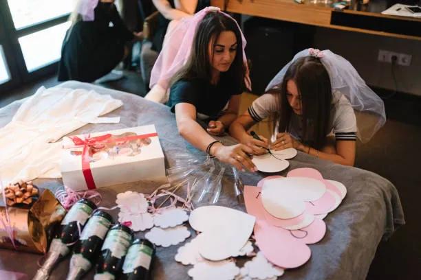 preparation d accessoires sur un lit lors d un atelier diy evjf a deauville avec deux participantes en train de creer