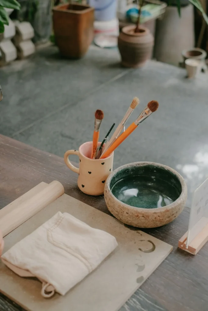 Matériel de peinture sur céramique prêt pour un atelier créatif EVJF à domicile.