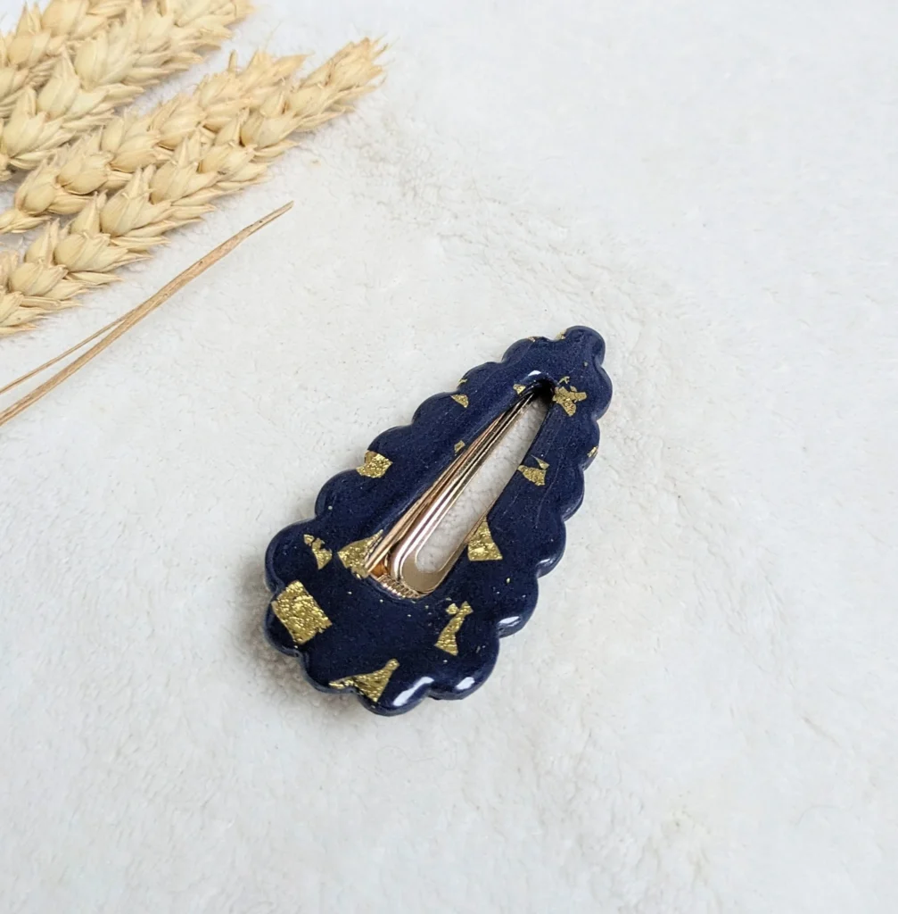 Barrette bleue et dorée fabriquée à la main en pâte Fimo pendant un atelier EVJF.