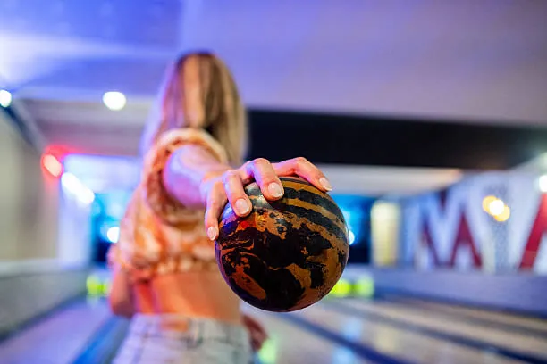 femme tenant une boule de bowling avant de lancer lors d un evjf a nantes