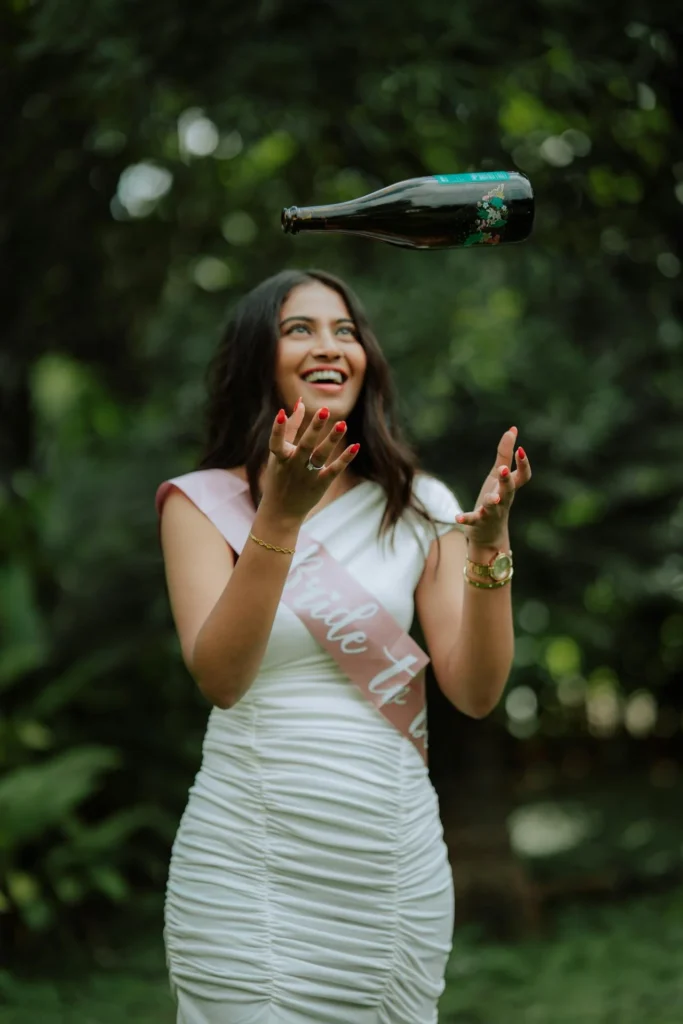 Future mariée souriante lançant une bouteille de vin lors de son EVJF